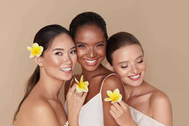 three diverse woman holding yellow flowers