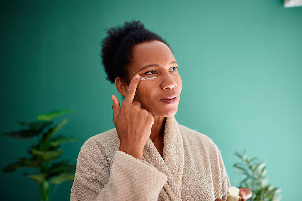 Woman applying eye cream — Cannabidiol CBD skincare blog