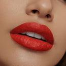 Close-up of a woman's lips with red lipstick on a neutral background