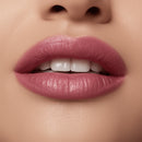 Close-up of a woman's lips with pink lipstick on a beige background