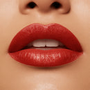 Close-up of a person's lips with red lipstick on a beige background