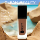 Foundation bottle with 'true colour BEAUTY' branding on a beach background, featuring clean beauty attributes.