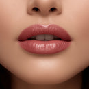 Close-up of a woman's lips with pink lipstick on a neutral background