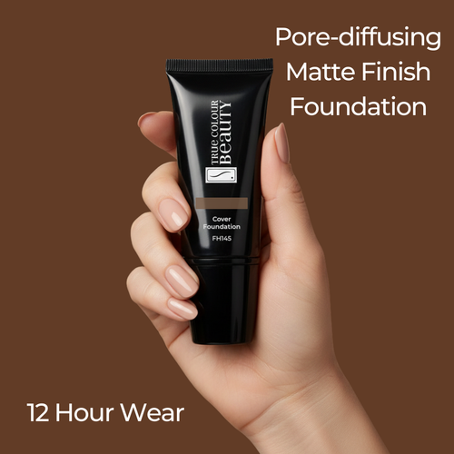Hand holding a black foundation tube with text about pore-diffusing matte finish foundation on a brown background