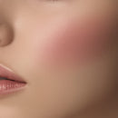 Close-up of a person's face with pink blush on cheek