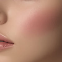 Close-up of a person's face with pink blush on cheek