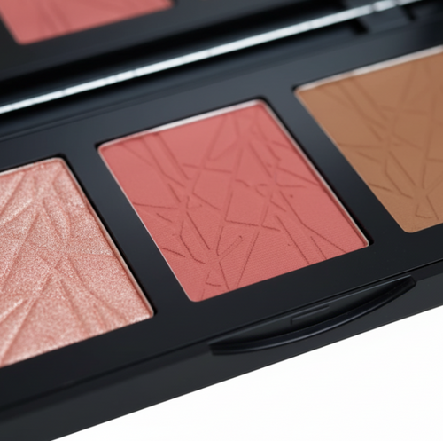 Makeup palette with three shades of blush and bronze on a white background