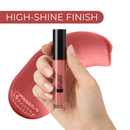 Lip gloss held by a hand with a high-shine finish label and pink swatch in the background