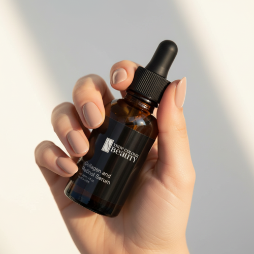 Hand holding a bottle of 'Prime Colours Beauty' serum against a neutral background