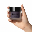 Hand holding a jar of 'True Colour Beauty' Glow Mask against a white background