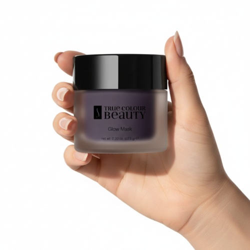 Hand holding a jar of 'True Colour Beauty' Glow Mask against a white background