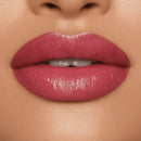 Close-up of a person's lips wearing a glossy pink lipstick.