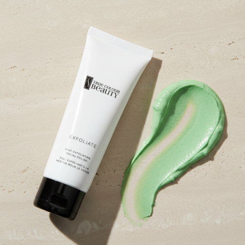 Tube of 'True Colour Beauty' exfoliating product with a swatch of green cream on a beige background