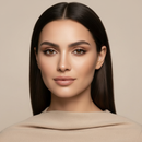 Woman with long dark hair wearing a beige sweater against a beige background