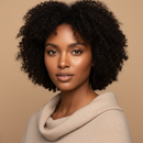 Woman with curly hair wearing a beige sweater against a beige background