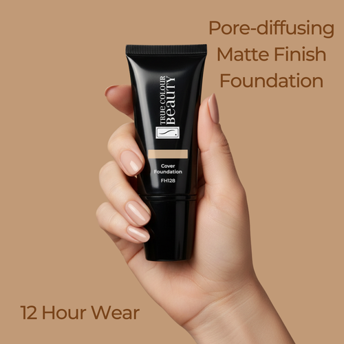 Hand holding a black foundation tube with text about pore-diffusing matte finish foundation on a beige background