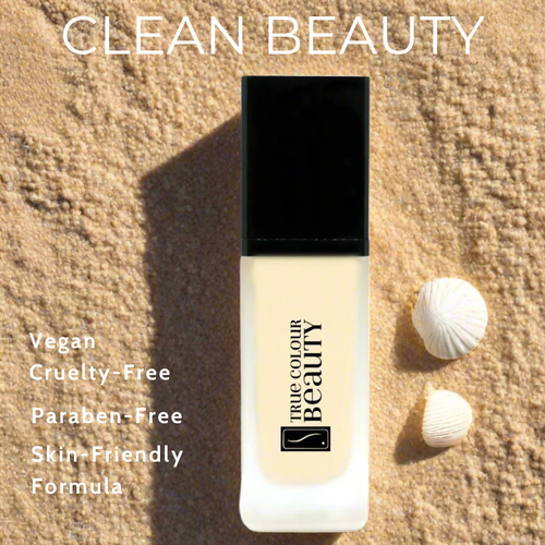 Foundation bottle with 'True Colour Beauty' branding on a sandy background with seashells.