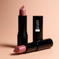 Pink lipstick with black packaging on a beige background
