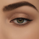 Close-up of a woman's eye with brown eyeshadow and eyeliner on a beige background