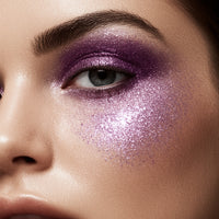 Close-up of a person's eye with purple glitter makeup