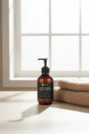 Bottle of 'Soft Skin' body wash on a bathroom counter with a white tiled wall background.
