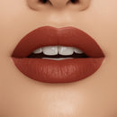 Close-up of a woman's lips with a matte lipstick on a beige background