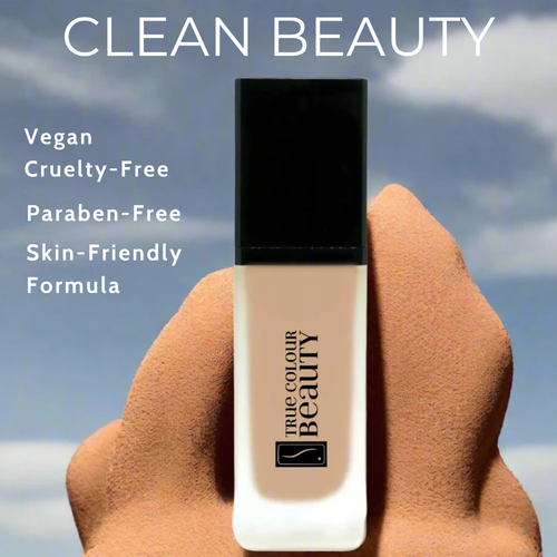 Foundation bottle held by a hand with 'True Colour Beauty' branding, set against a sky background.