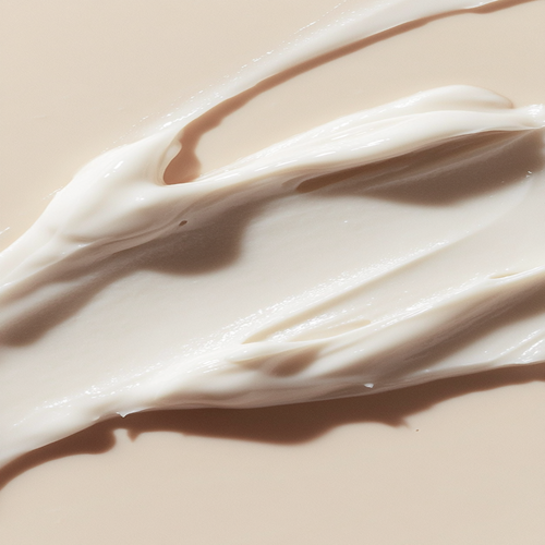 Close-up of a smooth, white cream on a beige background