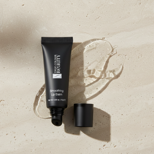 Black lip balm tube on a beige surface with 'True Colour Beauty' branding