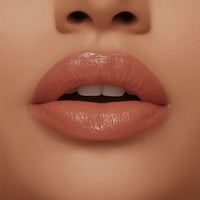 Close-up of a person's lips with a glossy lip color on a matching skin tone background