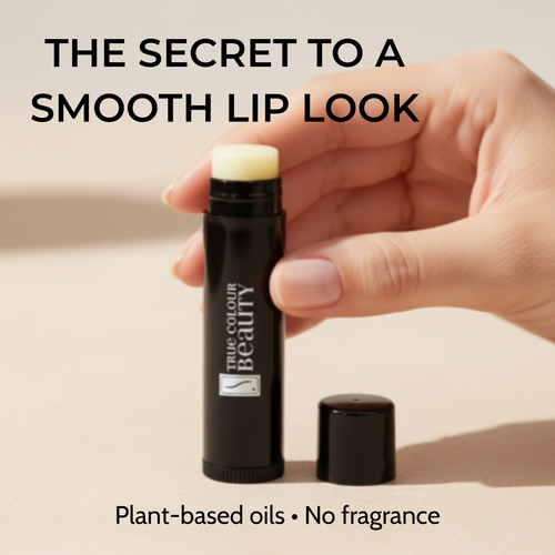 Hand holding a lip balm stick with 'True Colour Beauty' branding on a beige background.