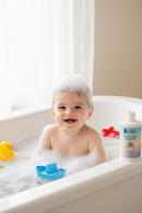 Baby in tub with toys and product