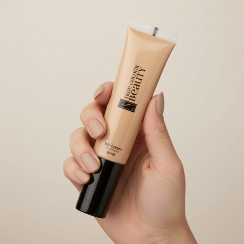 Hand holding a tube of True Color Beauty BB Cream against a beige background