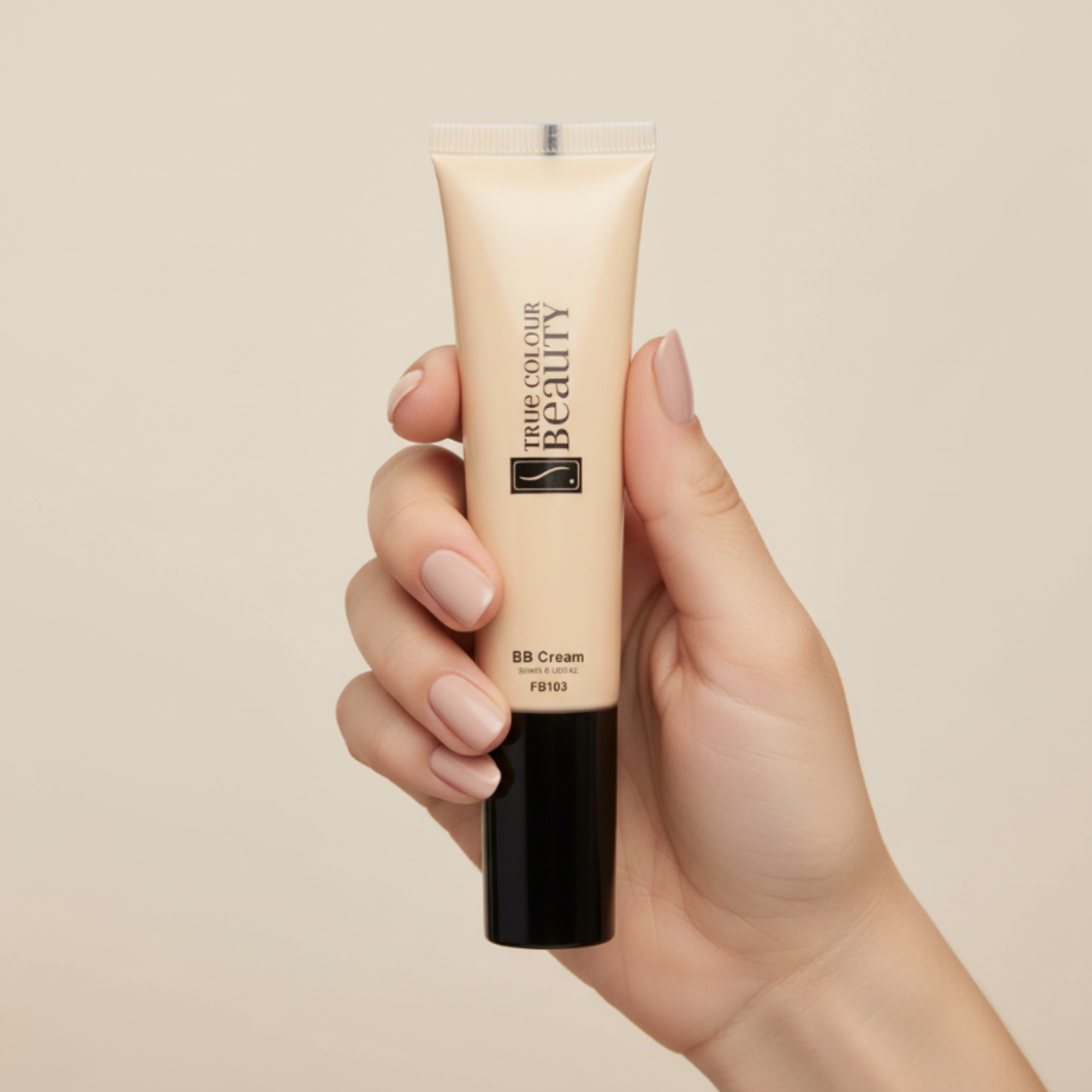 Hand holding a tube of BB cream with a beige background