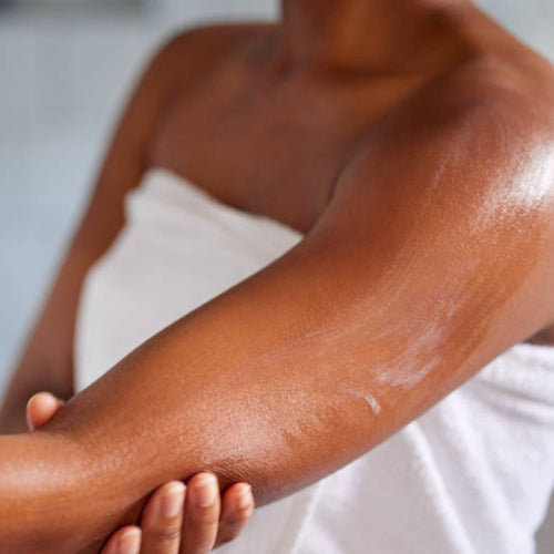 woman applying body butter to her arm.