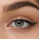 Close-up of a person's eye with green iris and brown eyelashes.