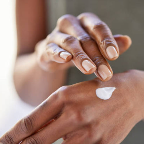 Applying hand cream to the hands.