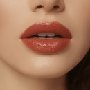 Close-up of a woman's lips with a glossy lipstick on a neutral background