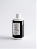 White bottle with a black label on a light gray background