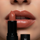 Close-up of a woman applying nude lipstick with the YSL brand visible.