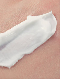 Close-up of a white cream being applied to skin