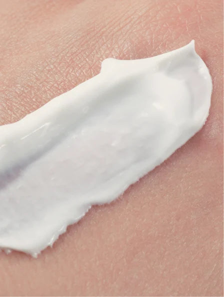 Close-up of a white cream being applied to skin