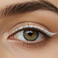 Close-up of a person's eye with green iris and brown eyebrow